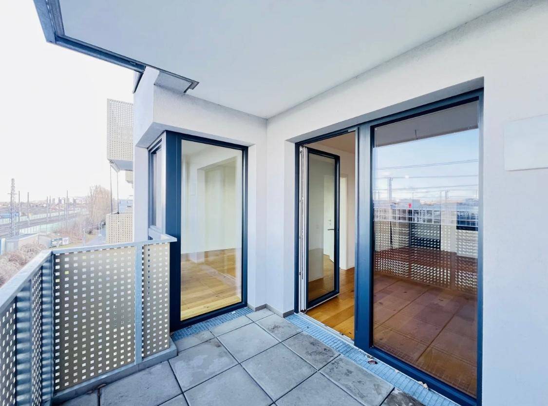Geräumiger Balkon mit Fliesenboden und moderner Metallbrüstung, ideal für Entspannung.
