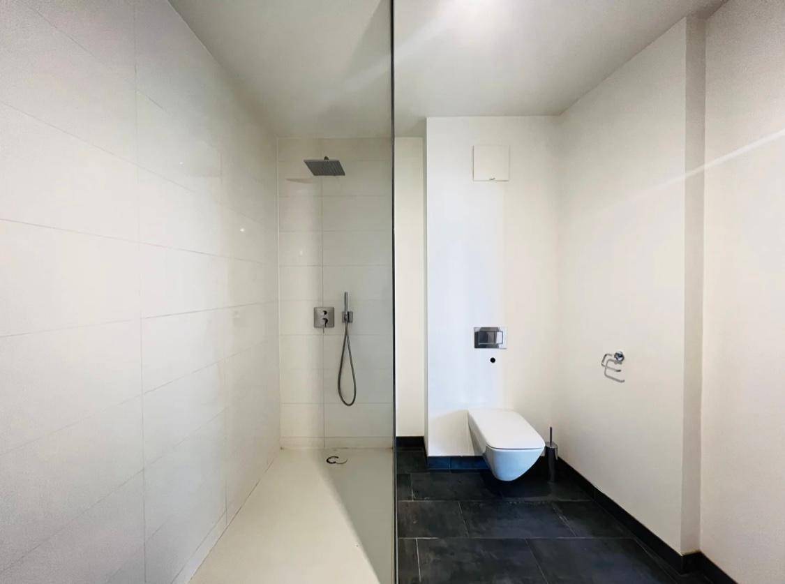 Zeitgemäßes Badezimmer mit bodengleicher Dusche und wandhängendem WC.