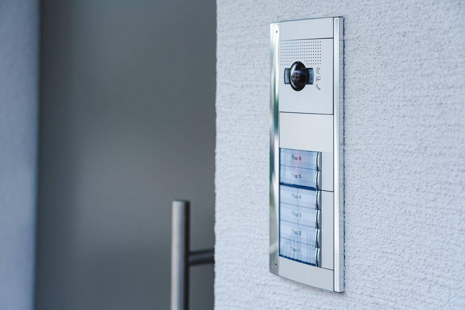 Moderne Gegensprechanlage mit integrierter Kamera und Klingeltasten für mehrere Wohneinheiten.
