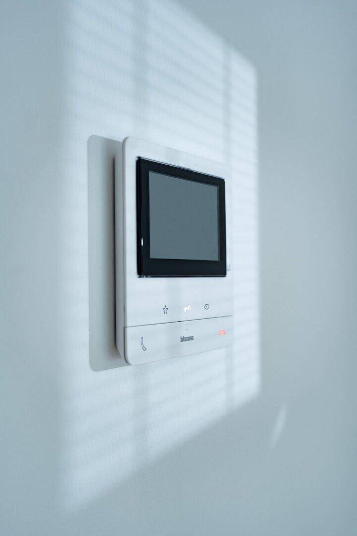 Innenansicht einer modernen Video-Gegensprechanlage an einer hellen Wand, mit Bildschirm.
