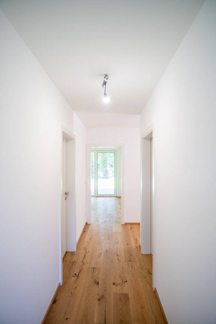 Heller Flur mit Holzboden und Türen zu verschiedenen Räumen der Wohnung.