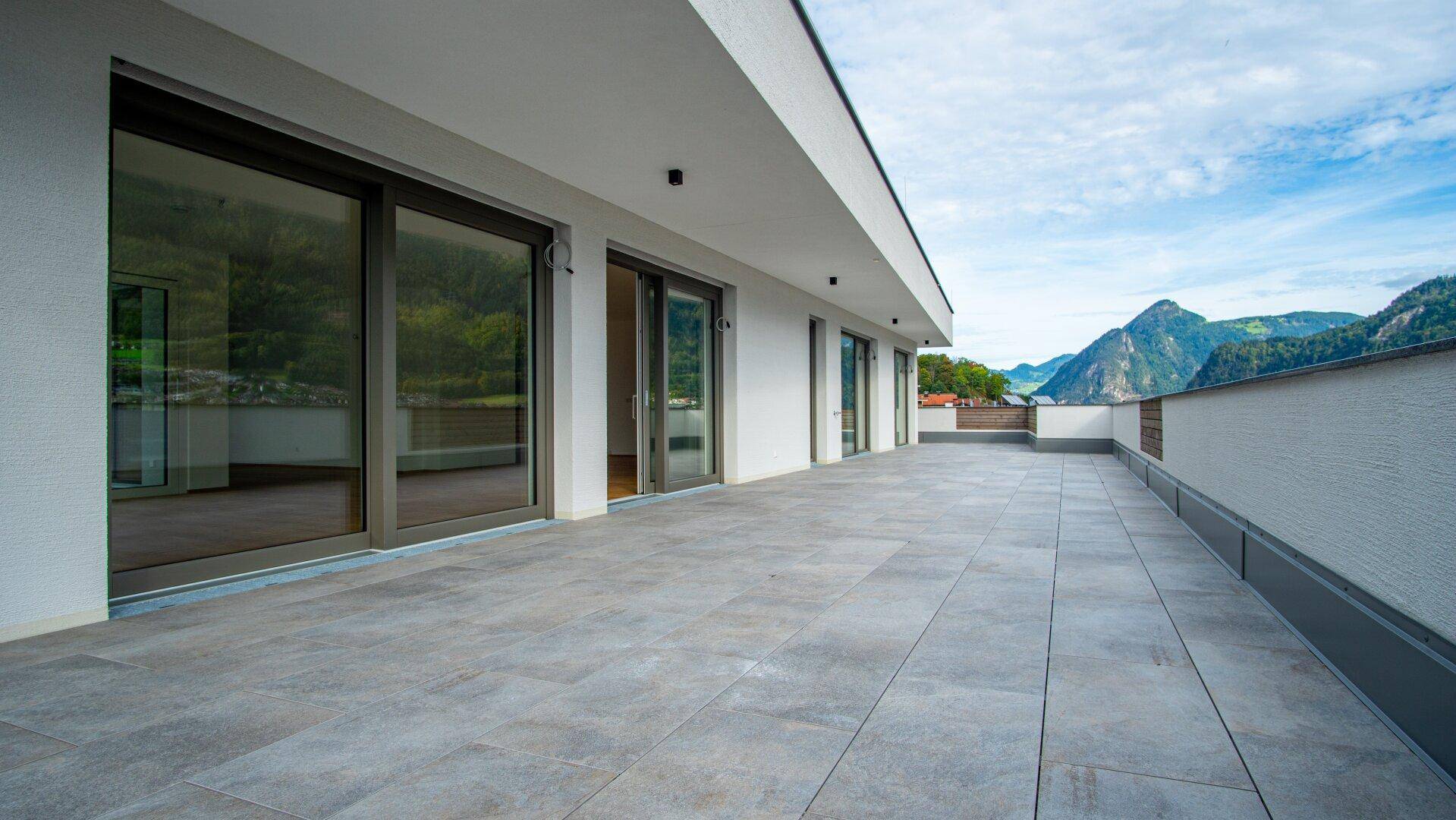 Weitläufige, geflieste Terrasse mit Bergblick und viel Platz für Outdoor-Möbel.