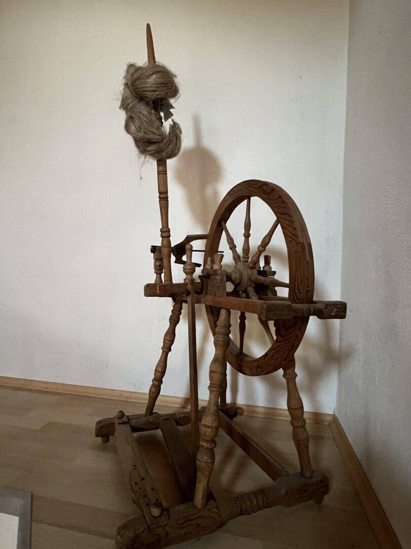 Altes, kunstvoll geschnitztes Spinnrad aus Holz als traditionelles Dekorationselement.