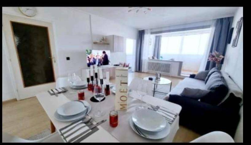 Einladender Essbereich mit gedecktem Tisch, Kerzen und Blick auf den Wohnbereich mit Balkonzugang.