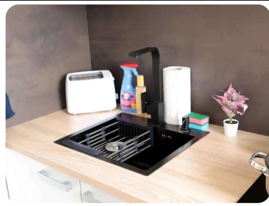 Detailansicht der modernen Küchenspüle mit schwarzem Wasserhahn und Holz-Arbeitsplatte.