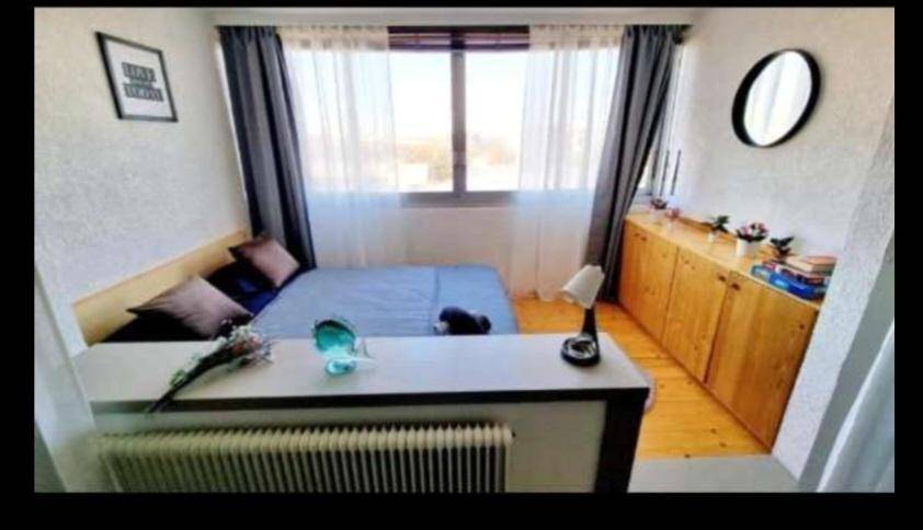 Helles Schlafzimmer mit Dielenboden, großem Fenster und praktischen Holzschränken.