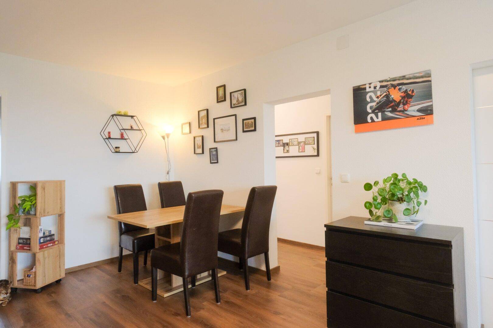 Gemütlicher Essbereich mit Holztisch, dunklen Stühlen und modernem Laminatboden.