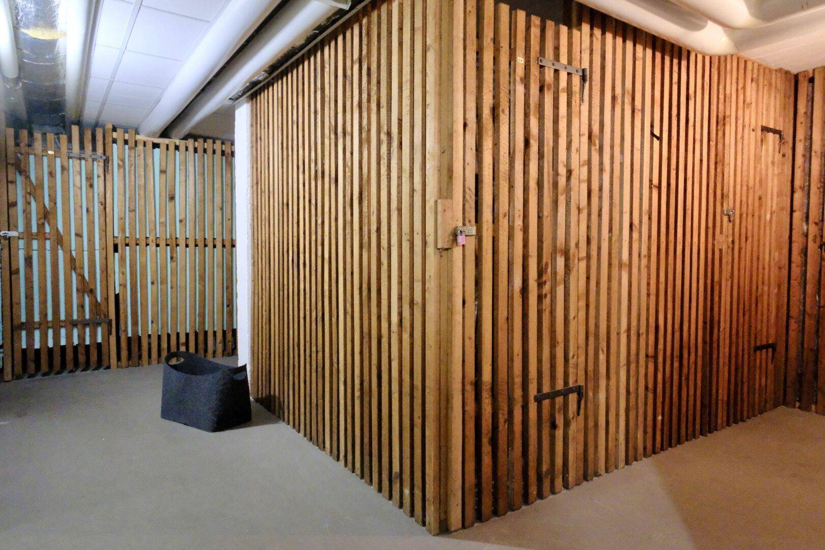 Kellerabteil mit Holzlattenwänden, ideal für zusätzlichen Stauraum.