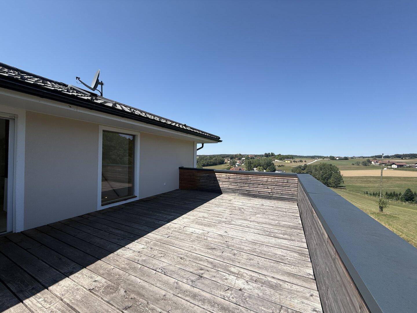 Große Dachterrasse aus Holz mit weitem Blick über die Landschaft.