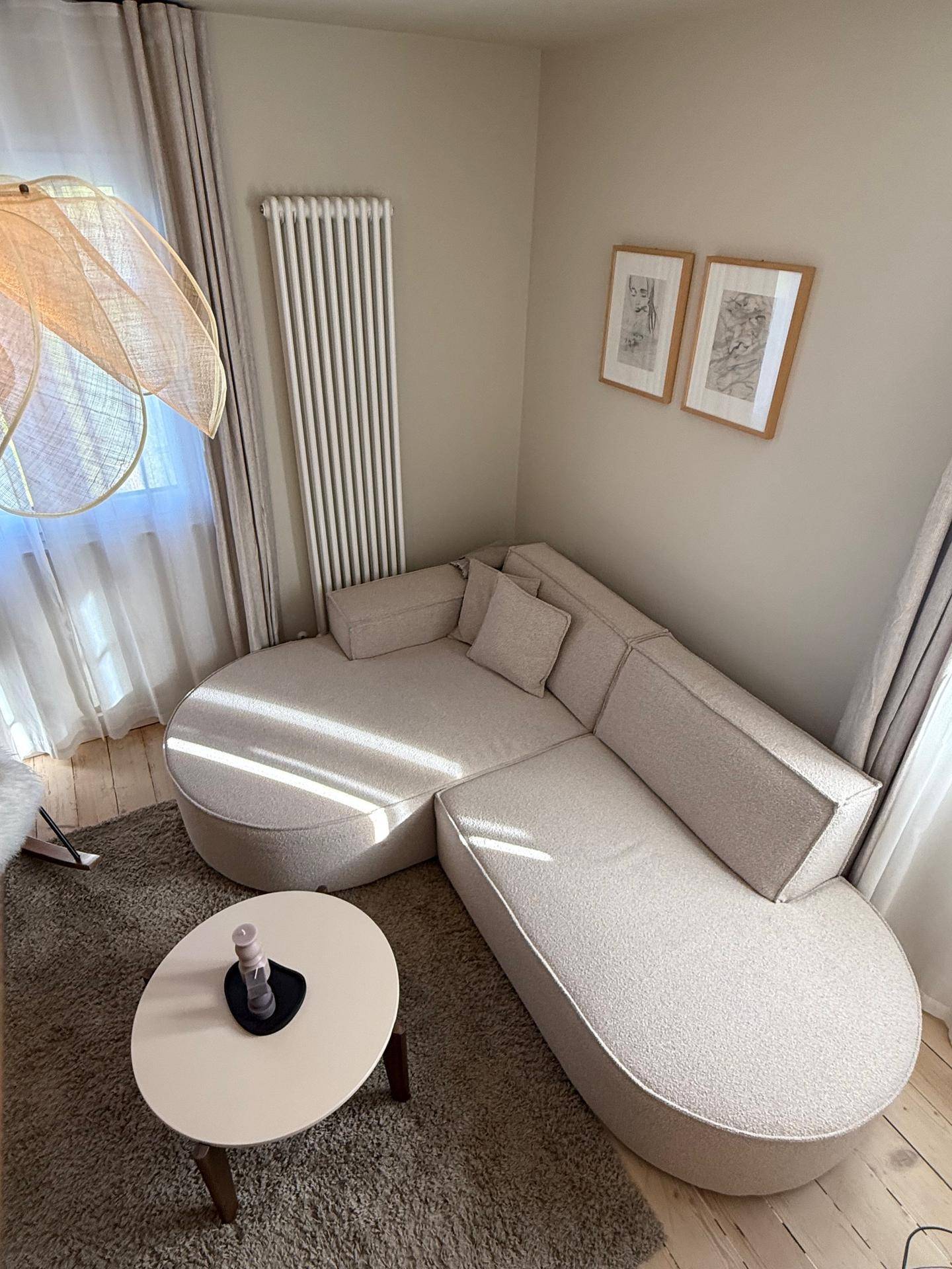 Detailansicht des modernen Ecksofas und des runden Couchtisches im Wohnzimmer.