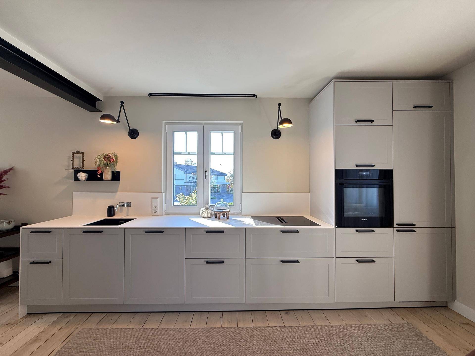 Voll ausgestattete moderne Küche mit integriertem Backofen, Spüle und Induktionskochfeld.
