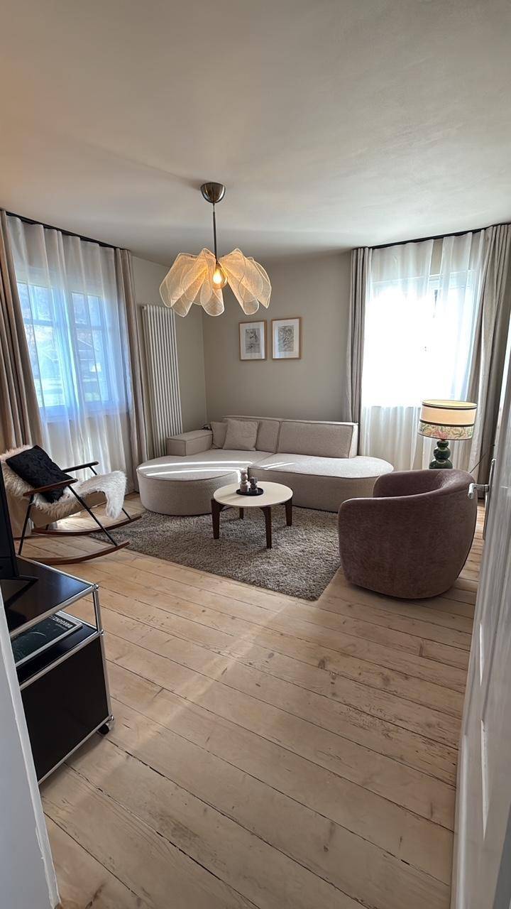Gemütliches Wohnzimmer mit großem Ecksofa, Couchtisch und hellem Holzfußboden.