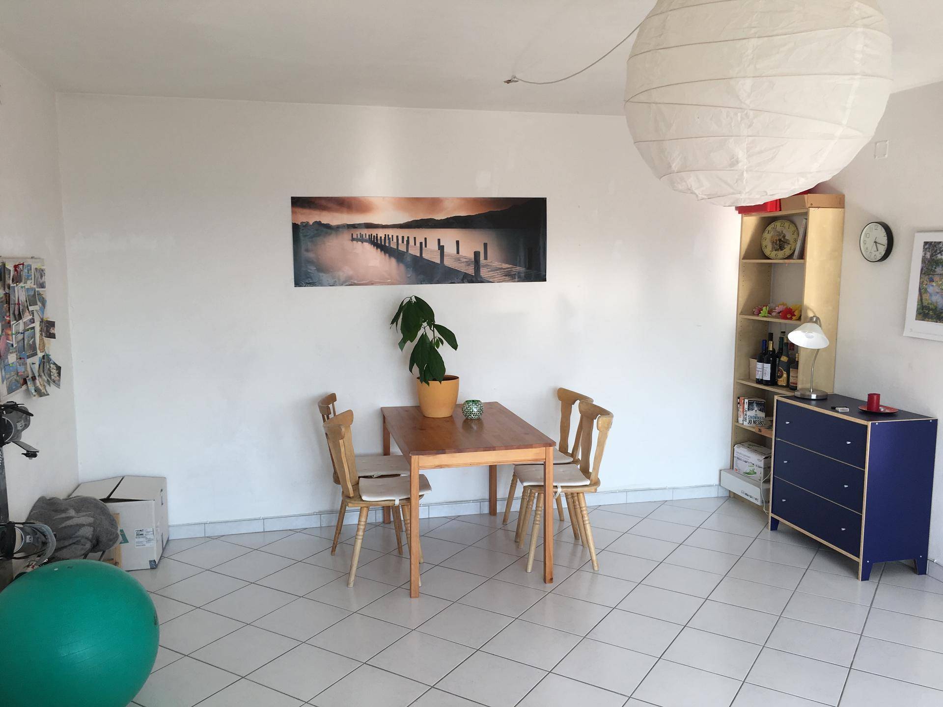 Heller Essbereich mit Holztisch und Stühlen, Teil eines offenen Wohn-Essbereichs mit Fliesenboden.
