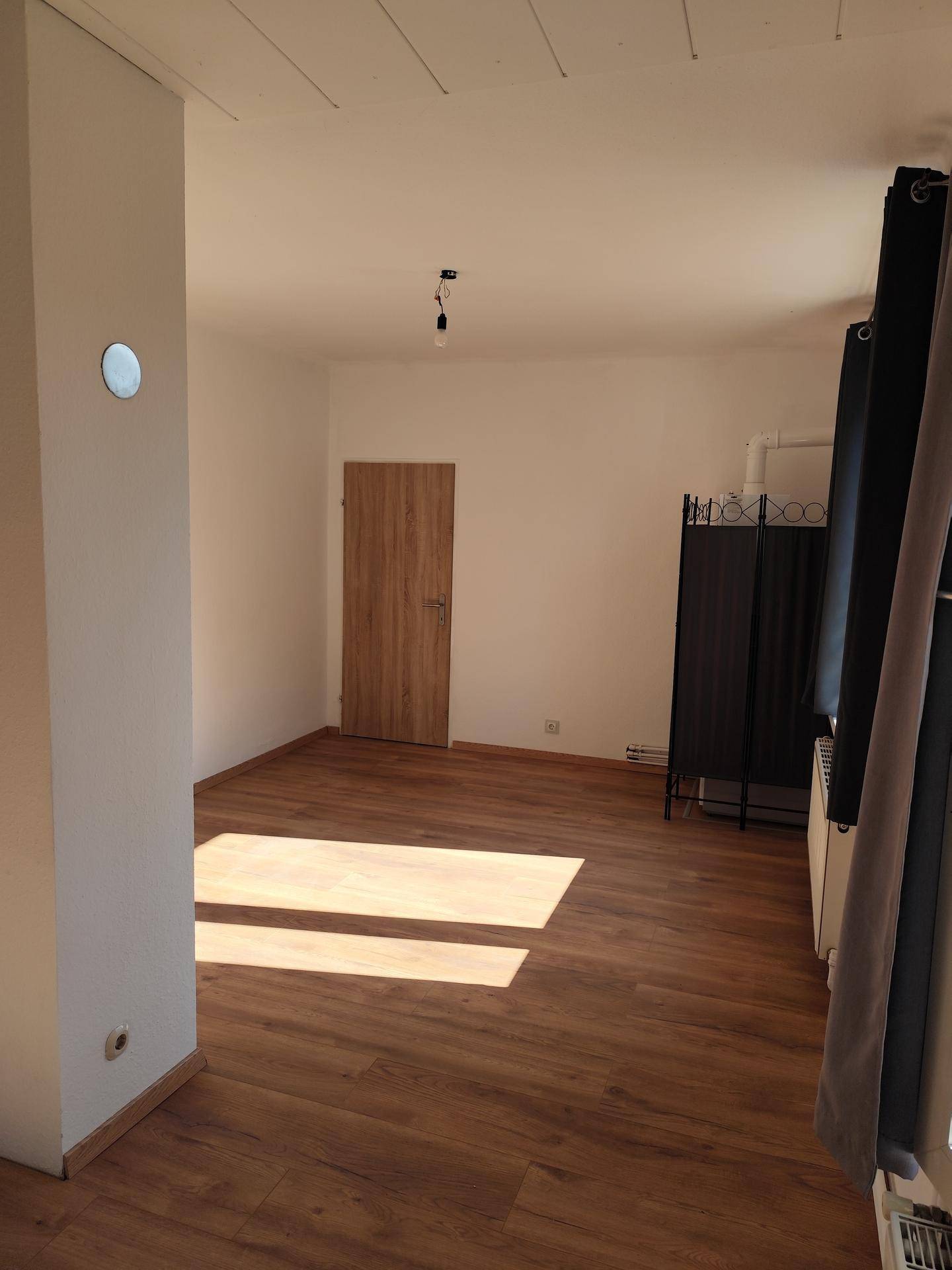 Lichtdurchfluteter Wohnbereich mit Laminatboden und viel Tageslicht, bereit zur Einrichtung.