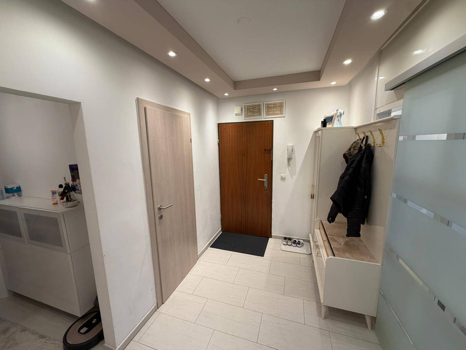 Eingangsbereich mit Garderobe, Einbaustrahlern und einer modernen Schiebetür.