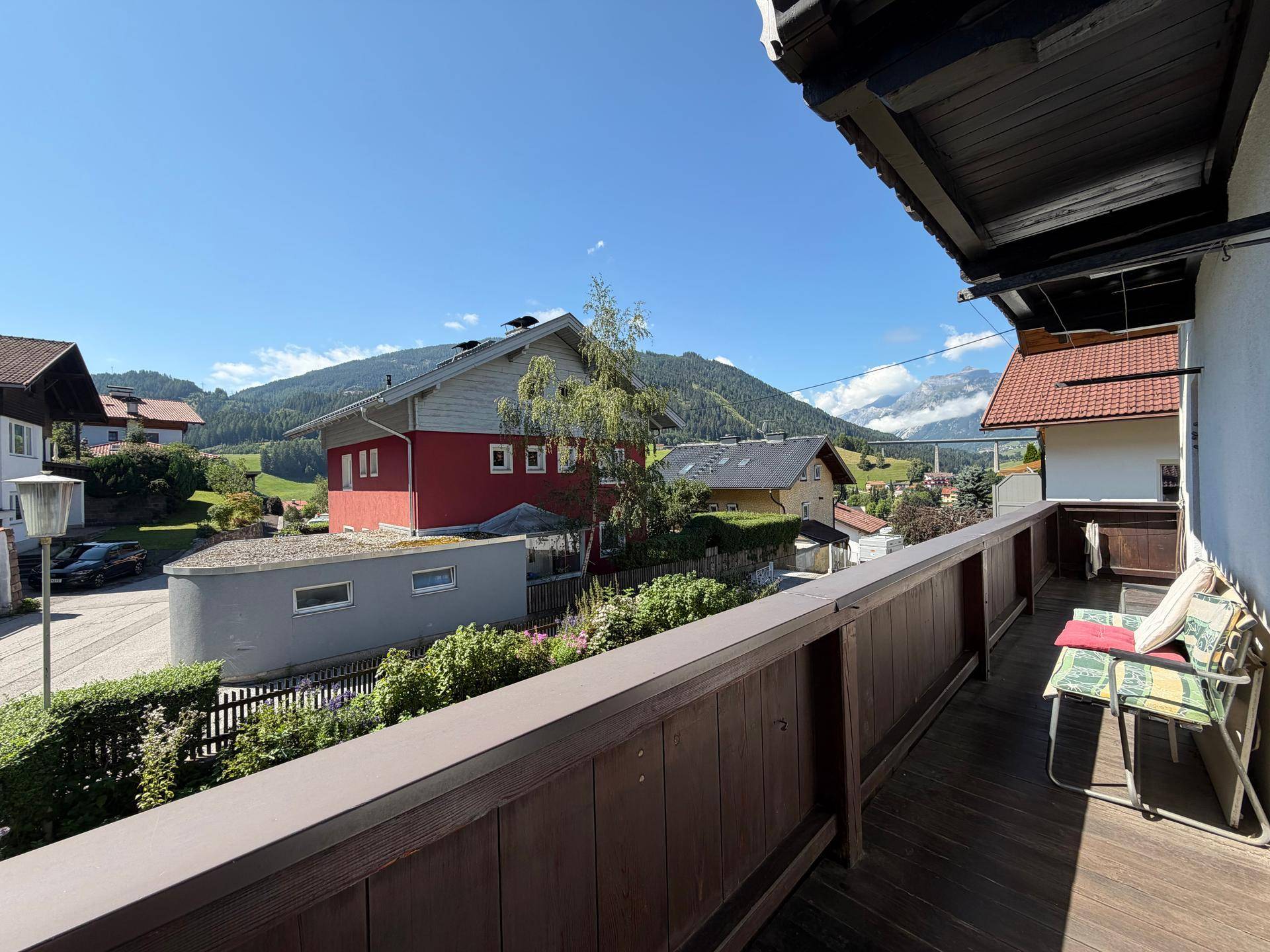 Geräumiger Balkon mit Sitzgelegenheiten und weitem Blick auf die umliegende Berglandschaft.