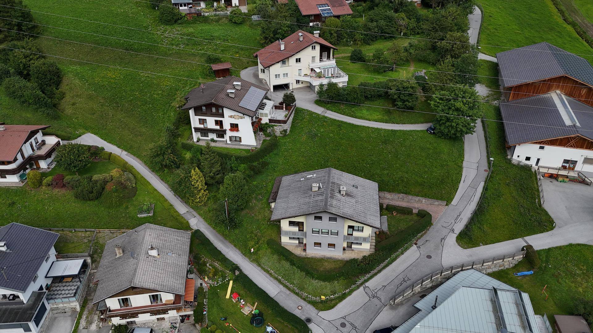 Übersicht aus der Vogelperspektive auf Wohnhäuser eingebettet in eine grüne, ländliche Umgebung.