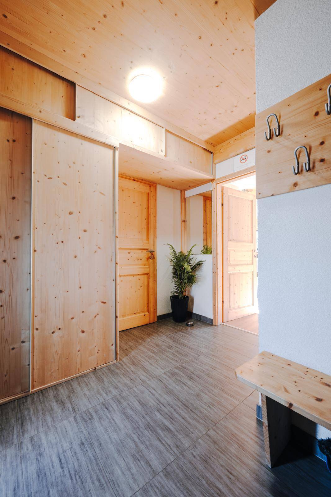 Geräumiger Eingangsbereich mit Holzvertäfelung, Garderobe und Fliesenboden.