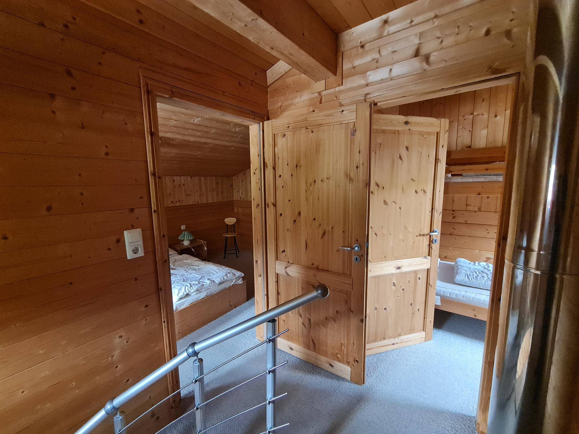Holzgetäfelter Flur mit Treppengeländer und Zugang zu den Schlafzimmern im Obergeschoss.
