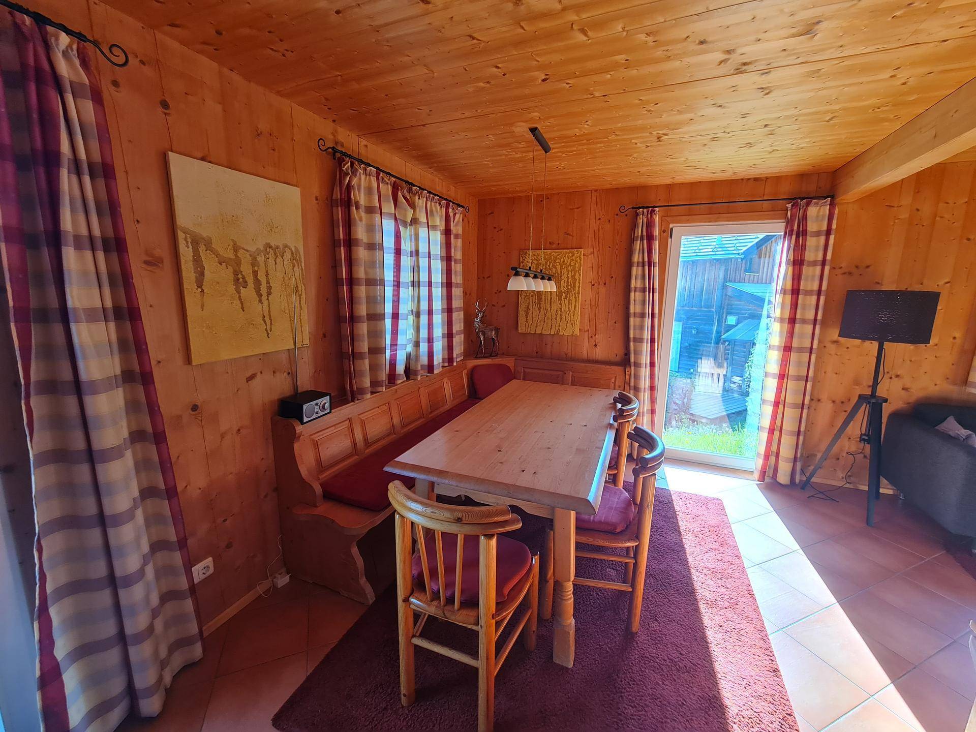 Essbereich mit traditioneller Eckbank, Holztisch und Zugang zur Terrasse.