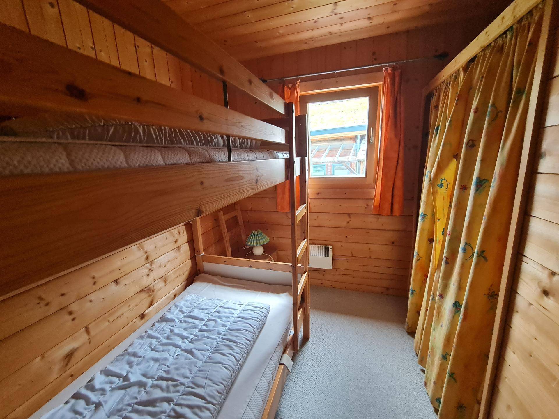 Kinderzimmer mit Etagenbett und Holzwänden, ideal für Gäste oder Familien.
