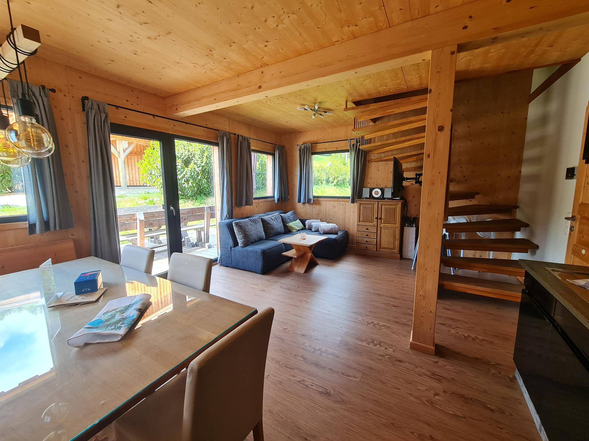 Heller Wohn- und Essbereich mit Zugang zur Terrasse und rustikalem Holzinterieur.