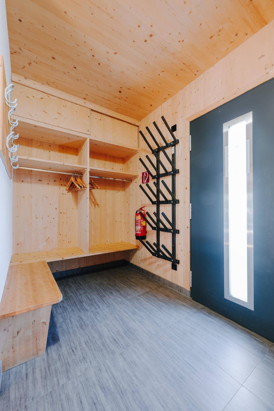 Eingangsbereich mit praktischer Skischuhheizung, Garderobe und Holzbank.