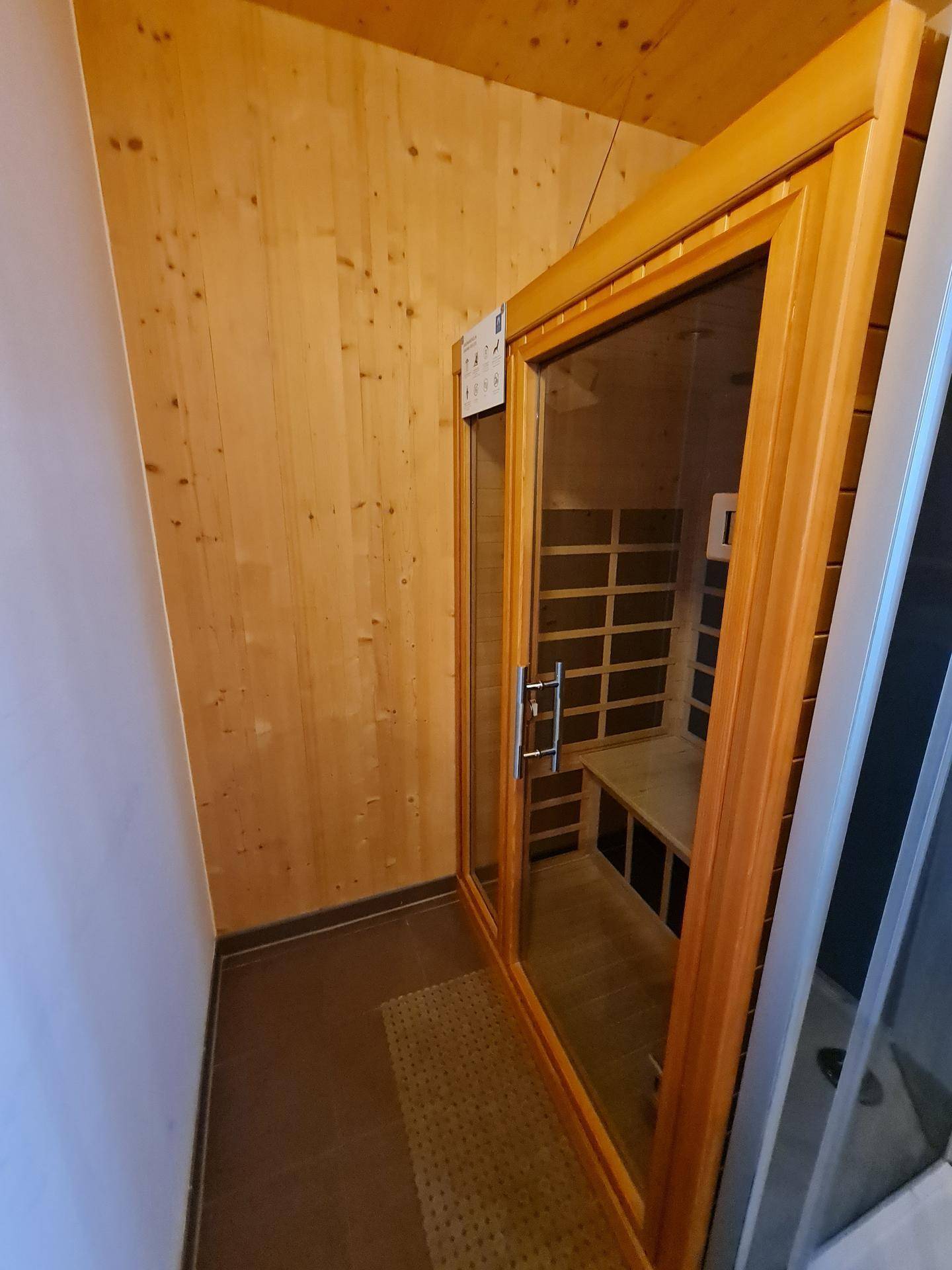 Private Sauna mit Holzbänken und Glastür für entspannende Momente.