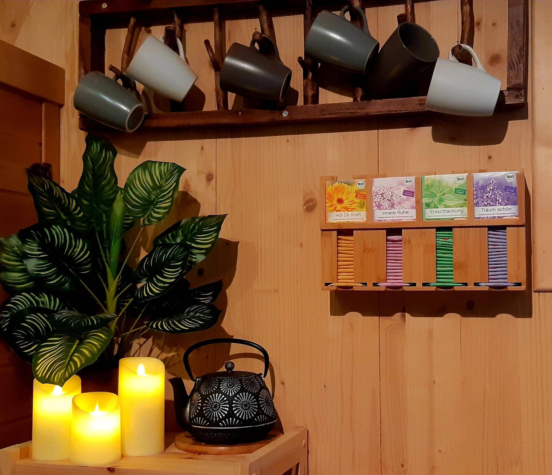 Gemütliche Tee-Ecke im Wellnessbereich mit Kerzen und verschiedenen Teesorten.