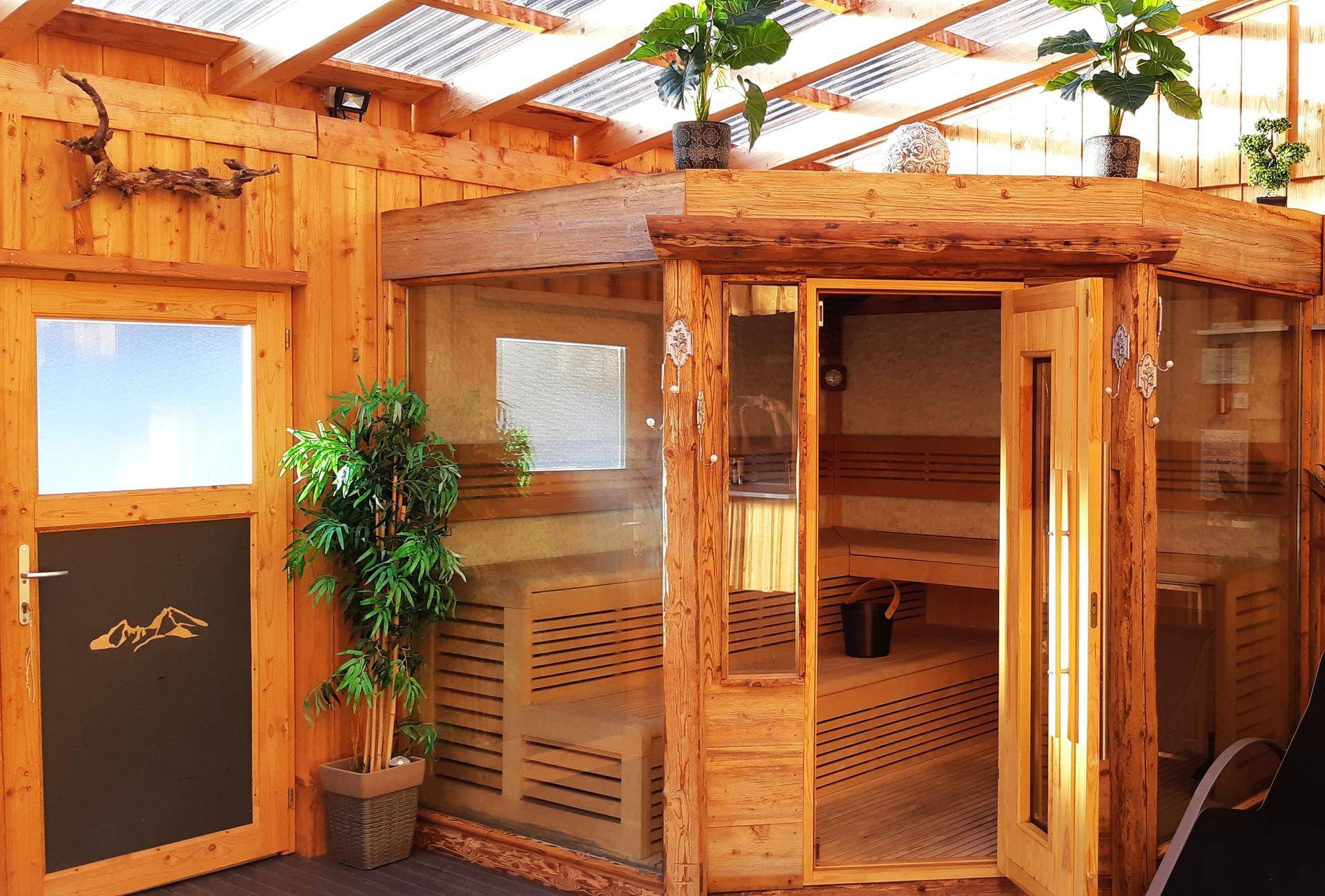 Geräumige Holzsauna mit Glasfront und traditionellen Bänken im Wellnessbereich.