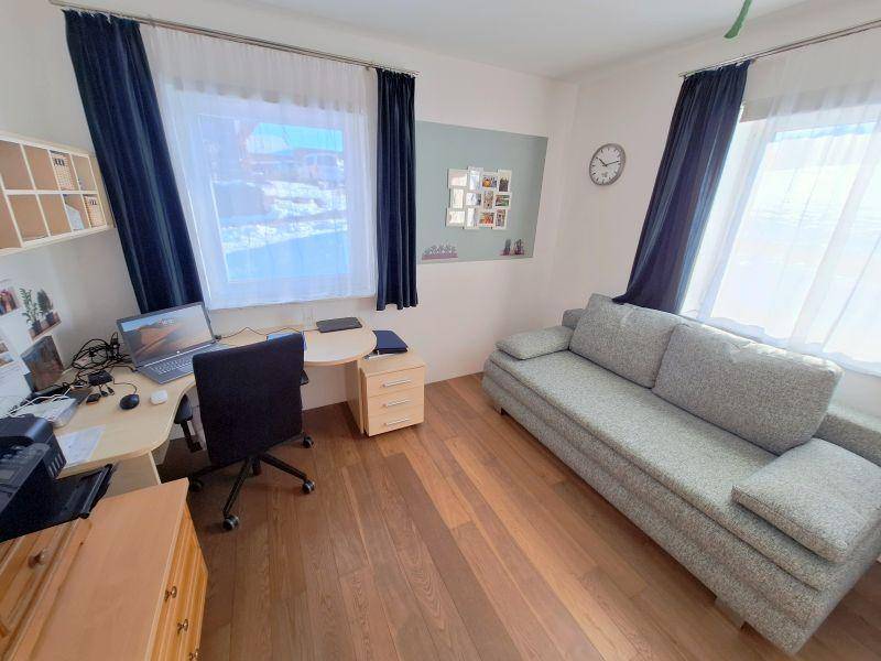 Arbeitszimmer mit Schreibtisch, Bürostuhl und Schlafsofa, ideal als Gästezimmer nutzbar.