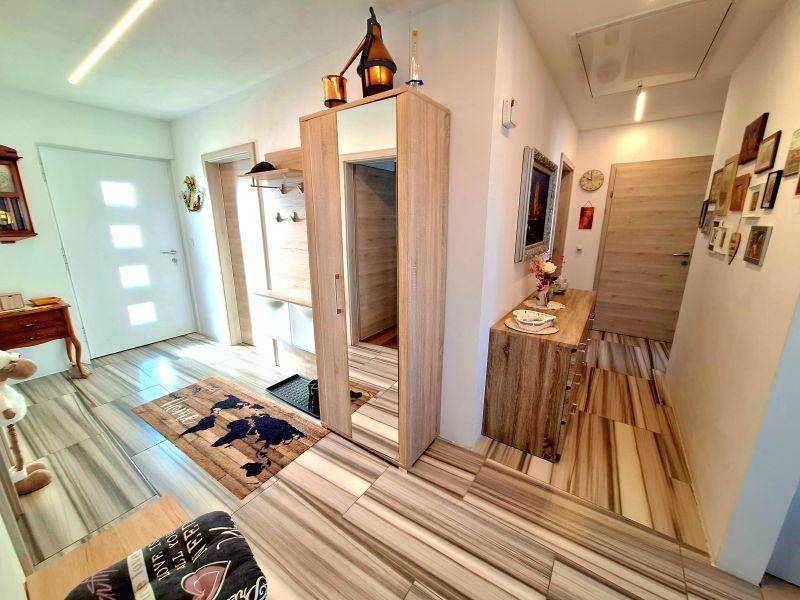 Einladende Diele mit modernem Fliesenboden, Garderobe und Spiegelschrank.