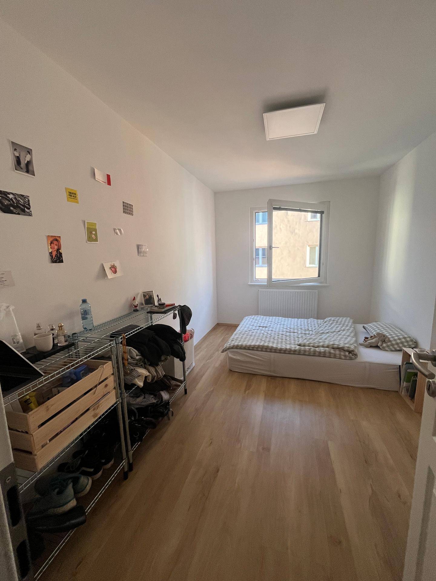Geräumiges Schlafzimmer mit hellem Holzboden, Einzelbett und einem Fenster für Tageslicht.
