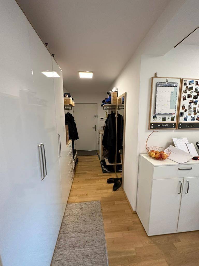 Flur mit Einbauschränken und Holzboden, der zusätzlichen Stauraum für Kleidung bietet.