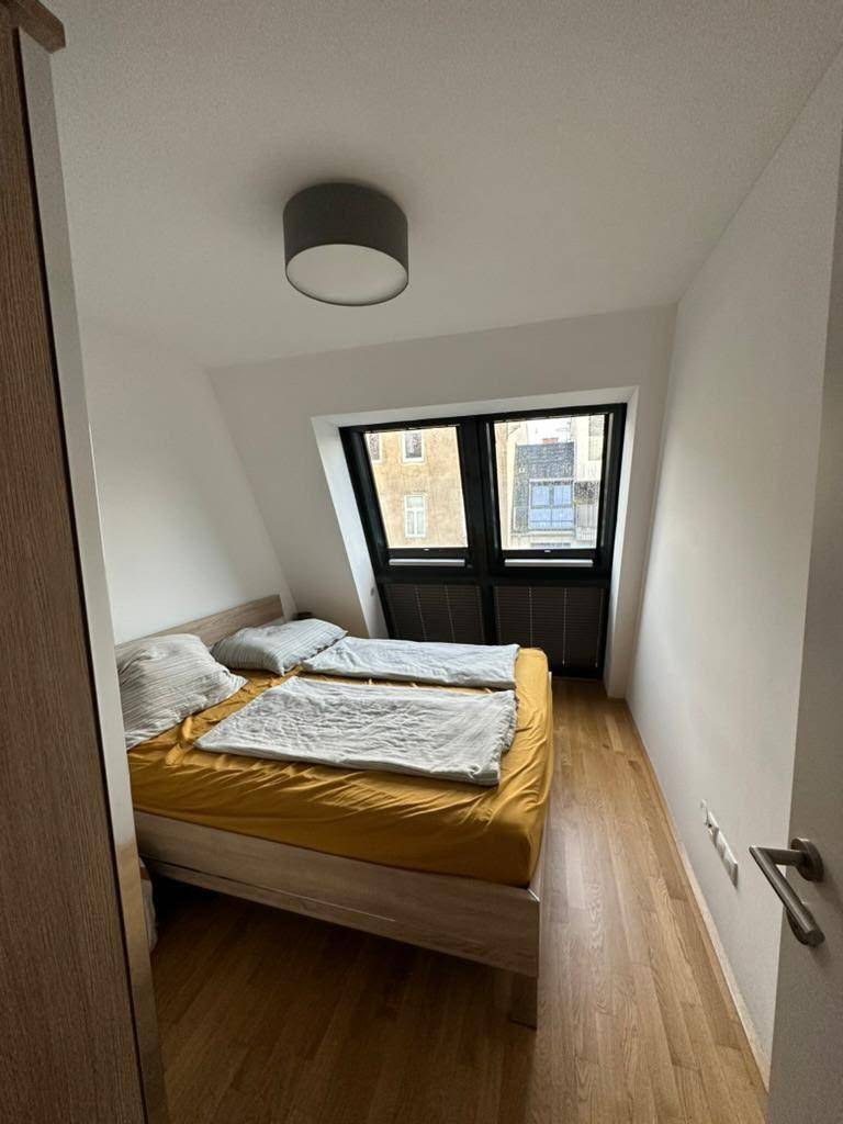 Gemütliches Schlafzimmer mit Holzboden, Doppelbett und schrägen Wänden im Dachgeschoss.