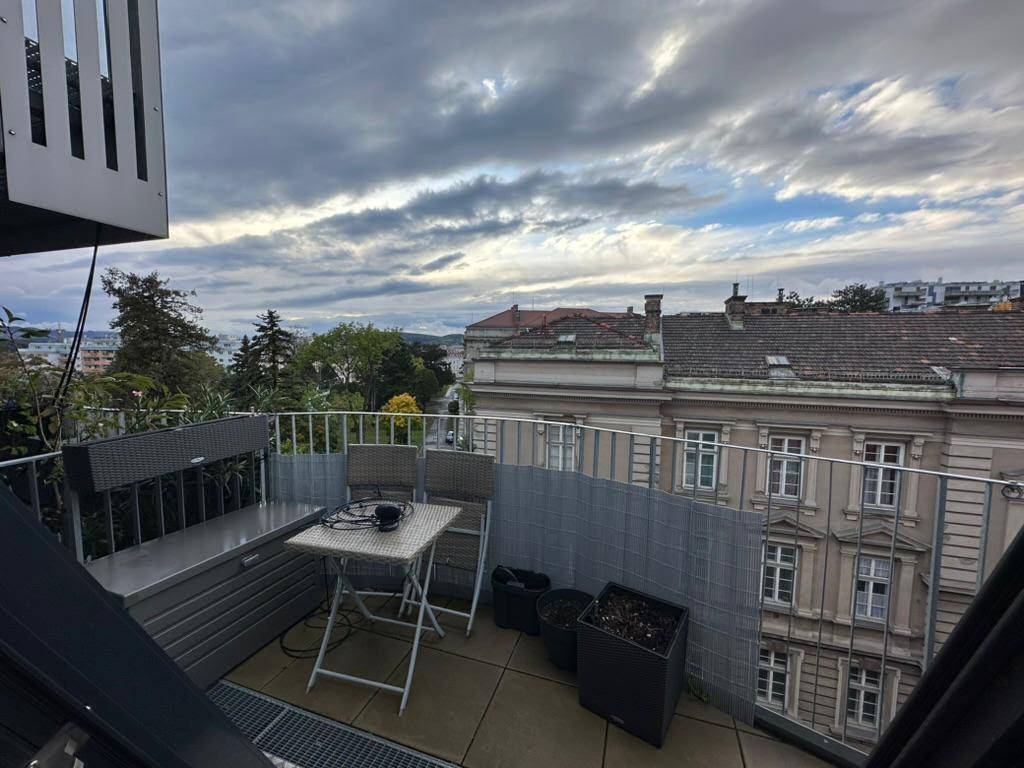 Gemütliche Dachterrasse mit Sitzgelegenheiten und Blick auf die umliegenden historischen Gebäude.