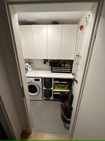 Praktischer Hauswirtschaftsraum mit Waschmaschine, Regalen und ausreichend Stauraum für Haushaltsgeräte.