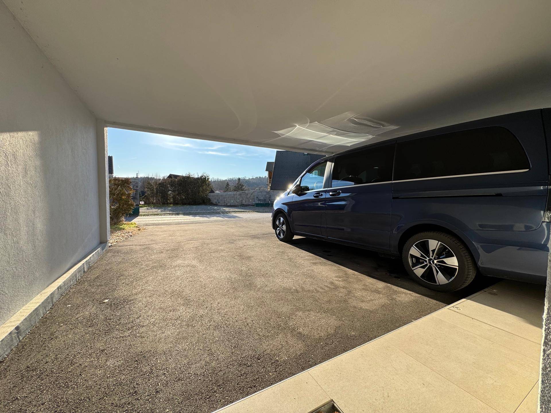 Überdachter Stellplatz im Carport mit Blick auf die sonnige Umgebung.