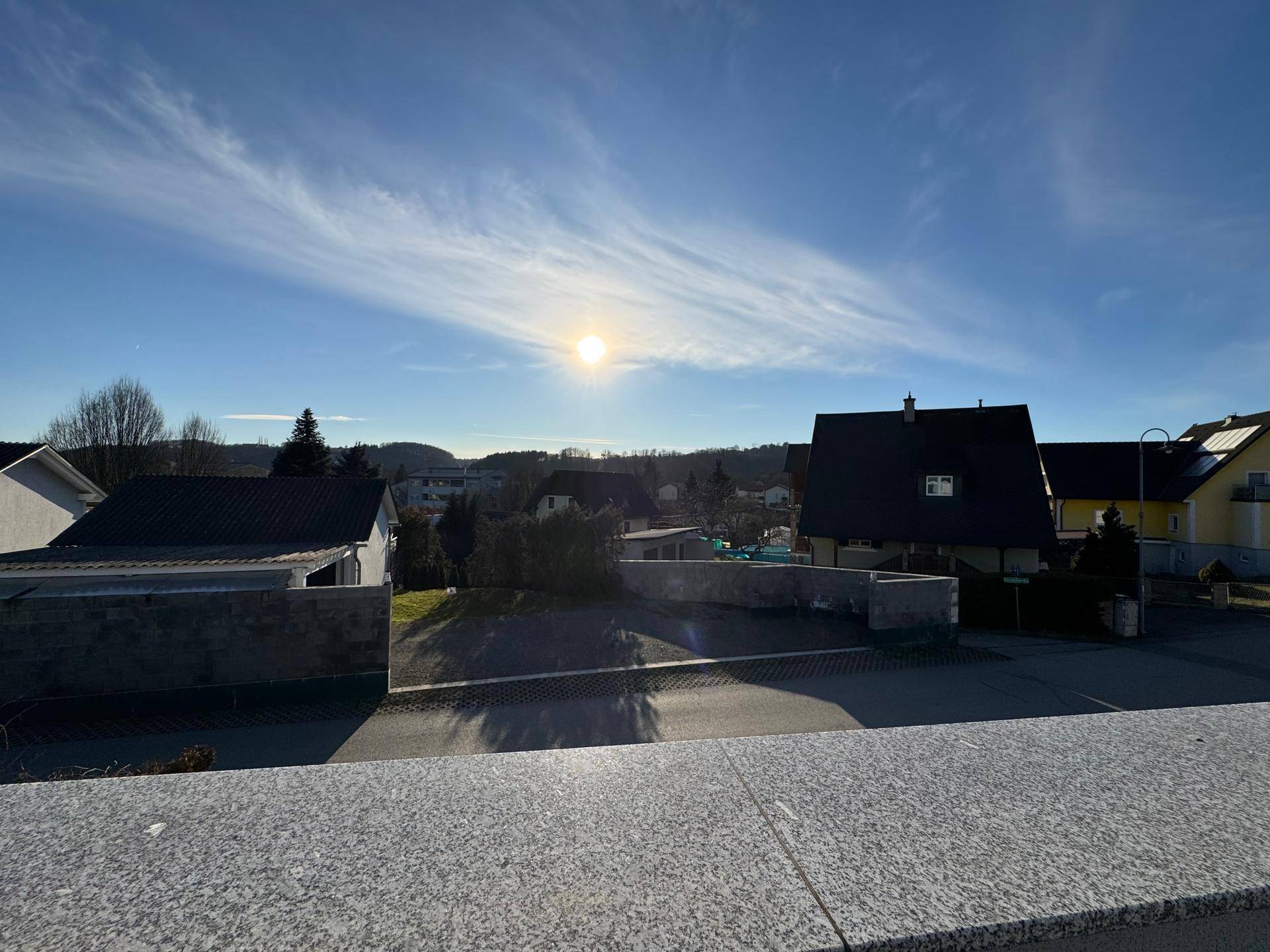 Weiter Ausblick von der Terrasse auf die umliegende Wohngegend unter blauem Himmel.