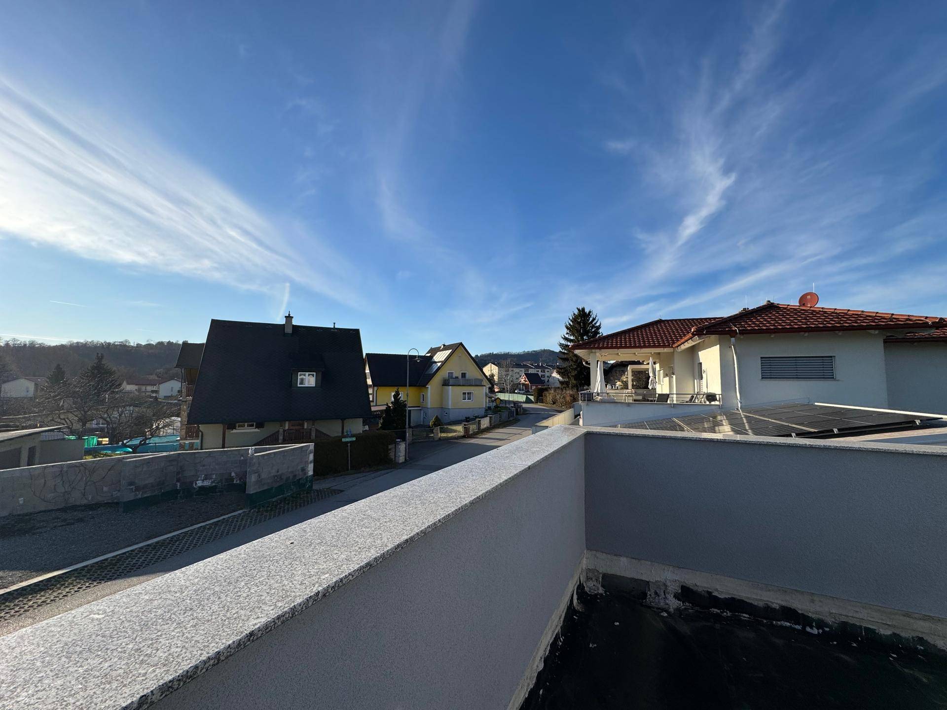 Panoramablick von der Dachterrasse über die Dächer der Nachbarschaft und die Landschaft.