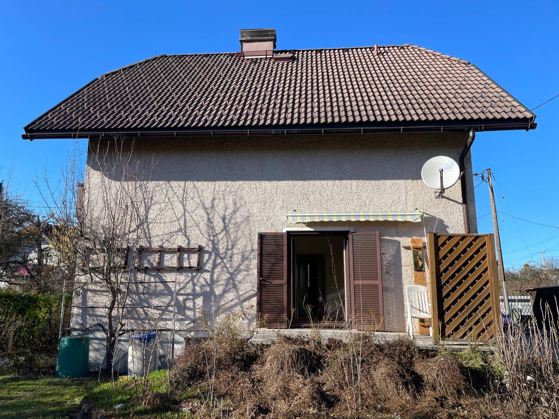 Rückseite des Hauses mit Terrasse, Markise und Blick in den Garten.