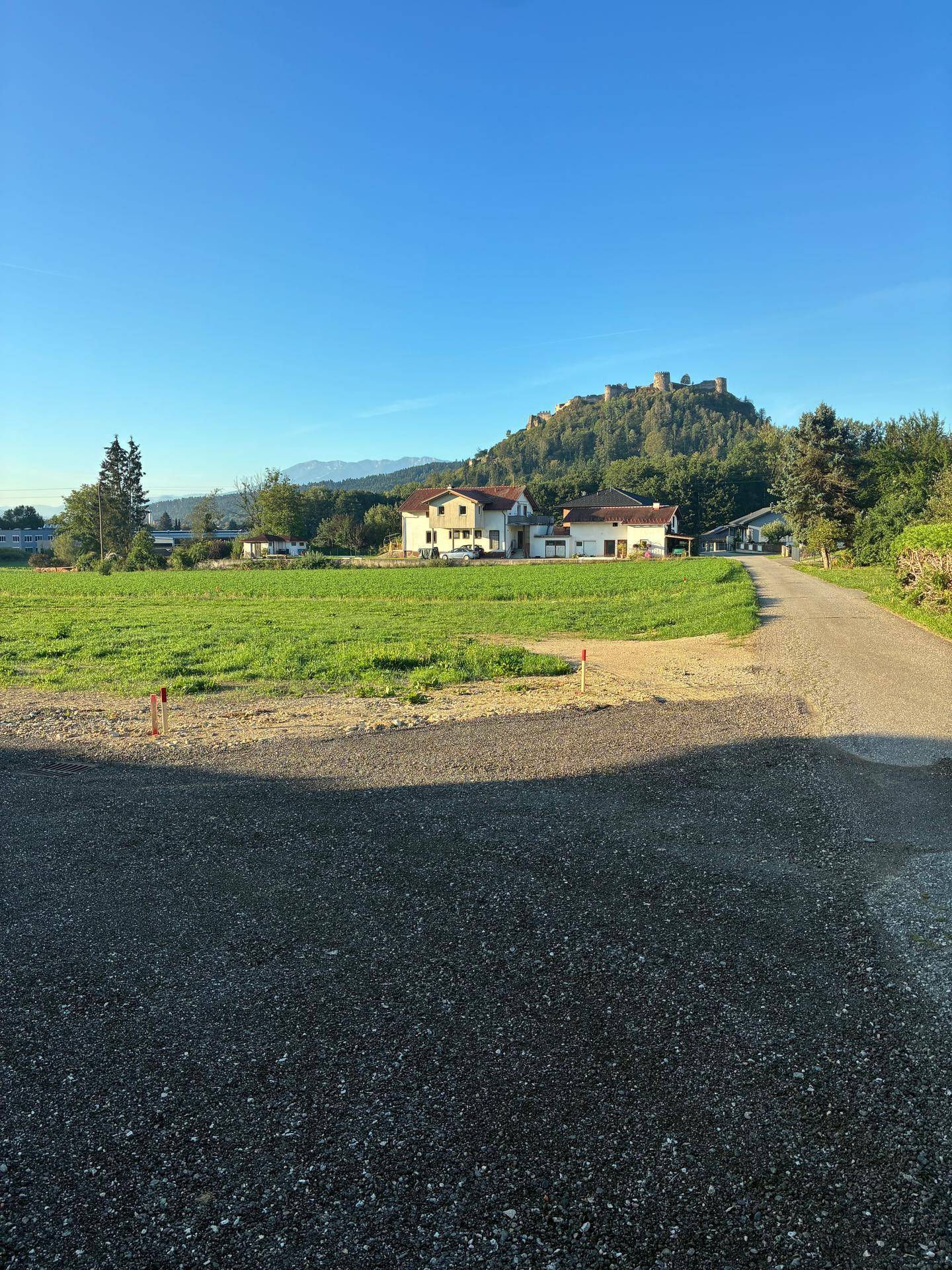 Haus in ländlicher Umgebung mit weitem Blick auf grüne Felder und eine Burgruine.