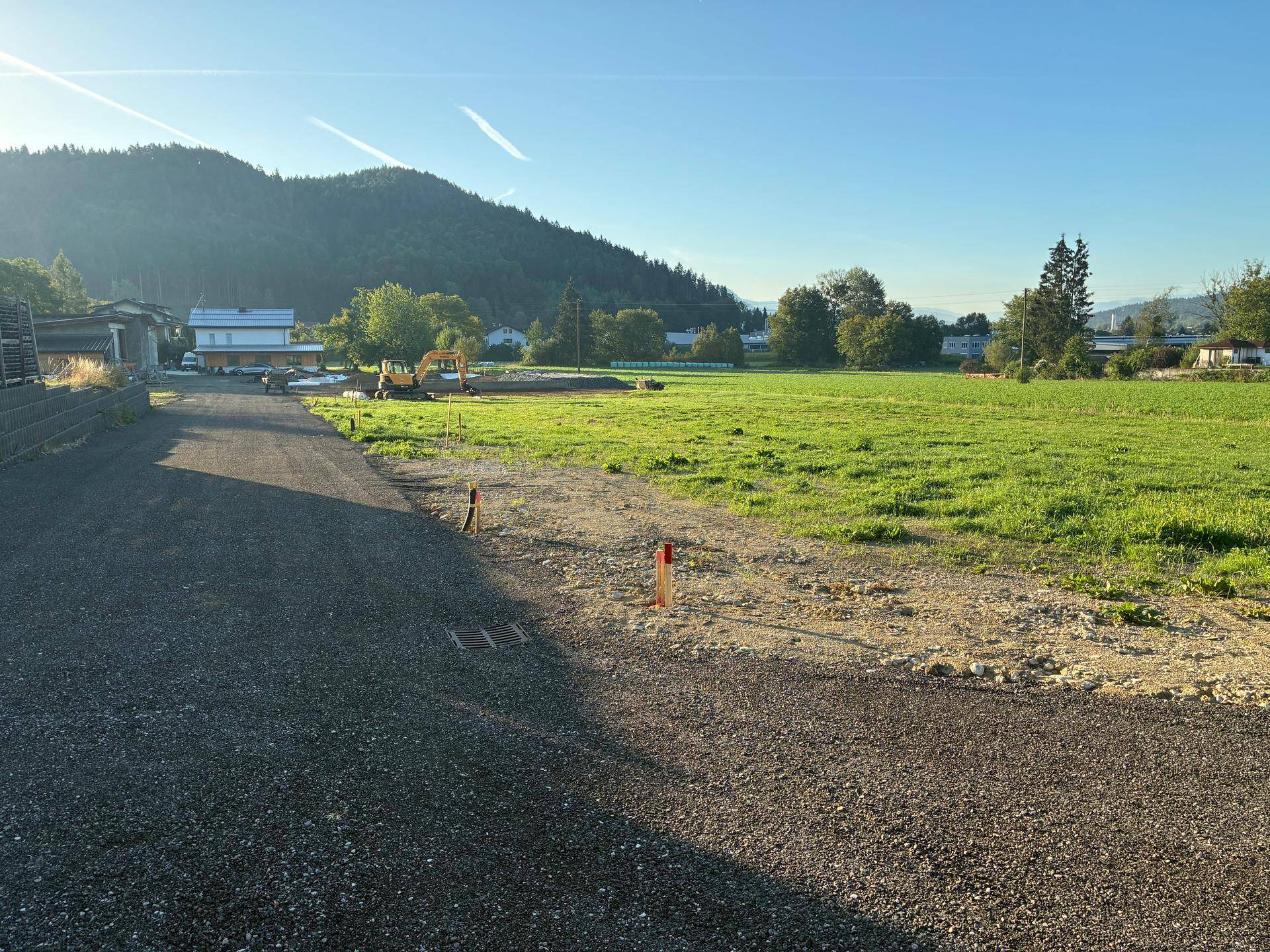 Sonniges Grundstück mit weitem Blick auf die umliegende Natur und Berge im Hintergrund.