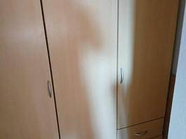 Heller Kleiderschrank mit mehreren Türen und Schubladen, passend zur Einrichtung.