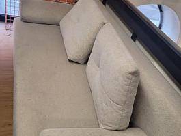Nahaufnahme eines bequemen Sofas mit Kissen in hellem Stoffbezug.