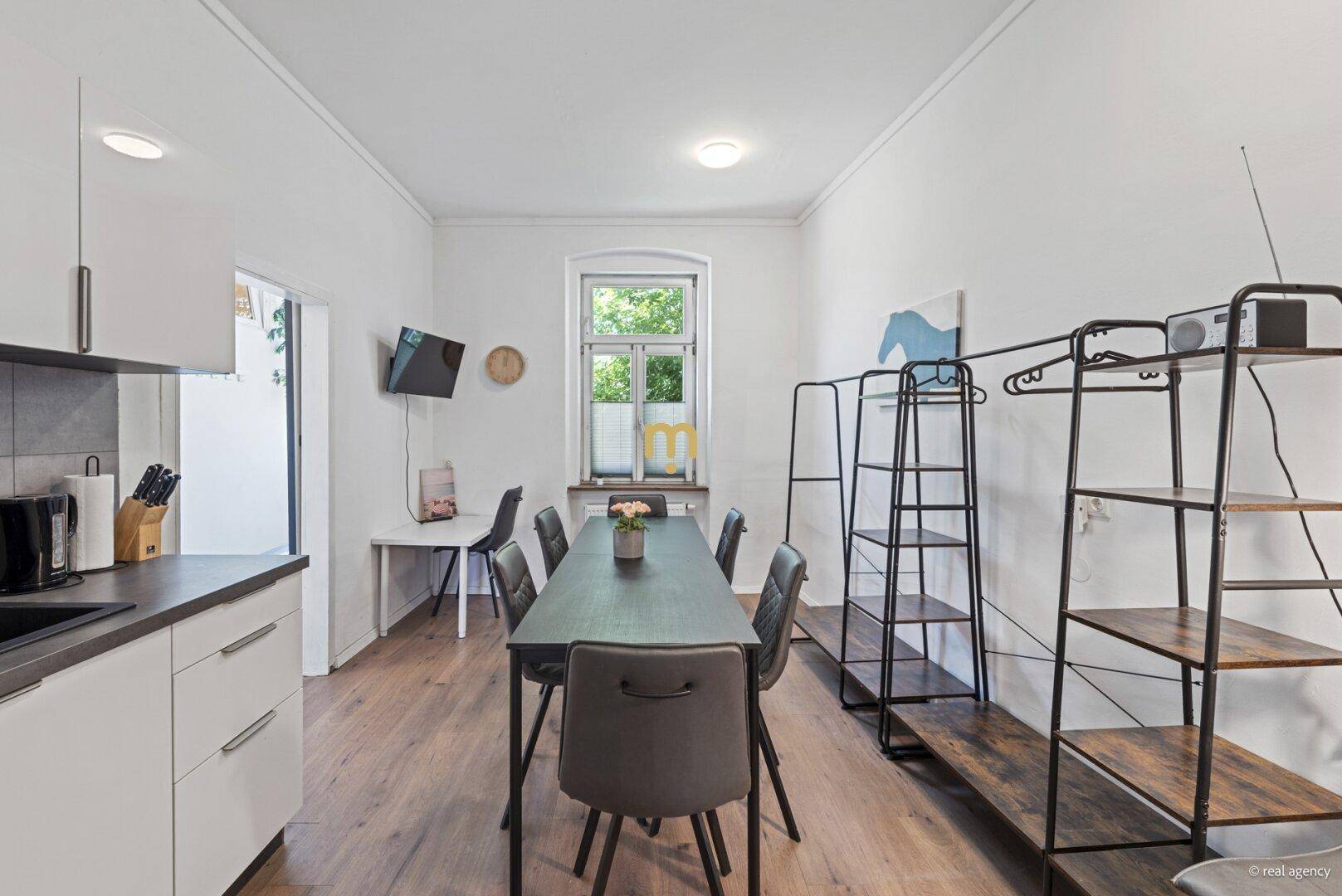 Geräumige Wohnküche mit modernem Esstisch und Fenster, ideal für gemeinsame Mahlzeiten.
