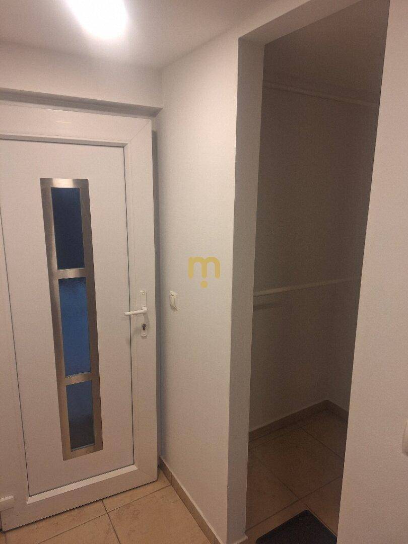 Eingangsbereich mit moderner Tür und praktischer Nische für Stauraum.