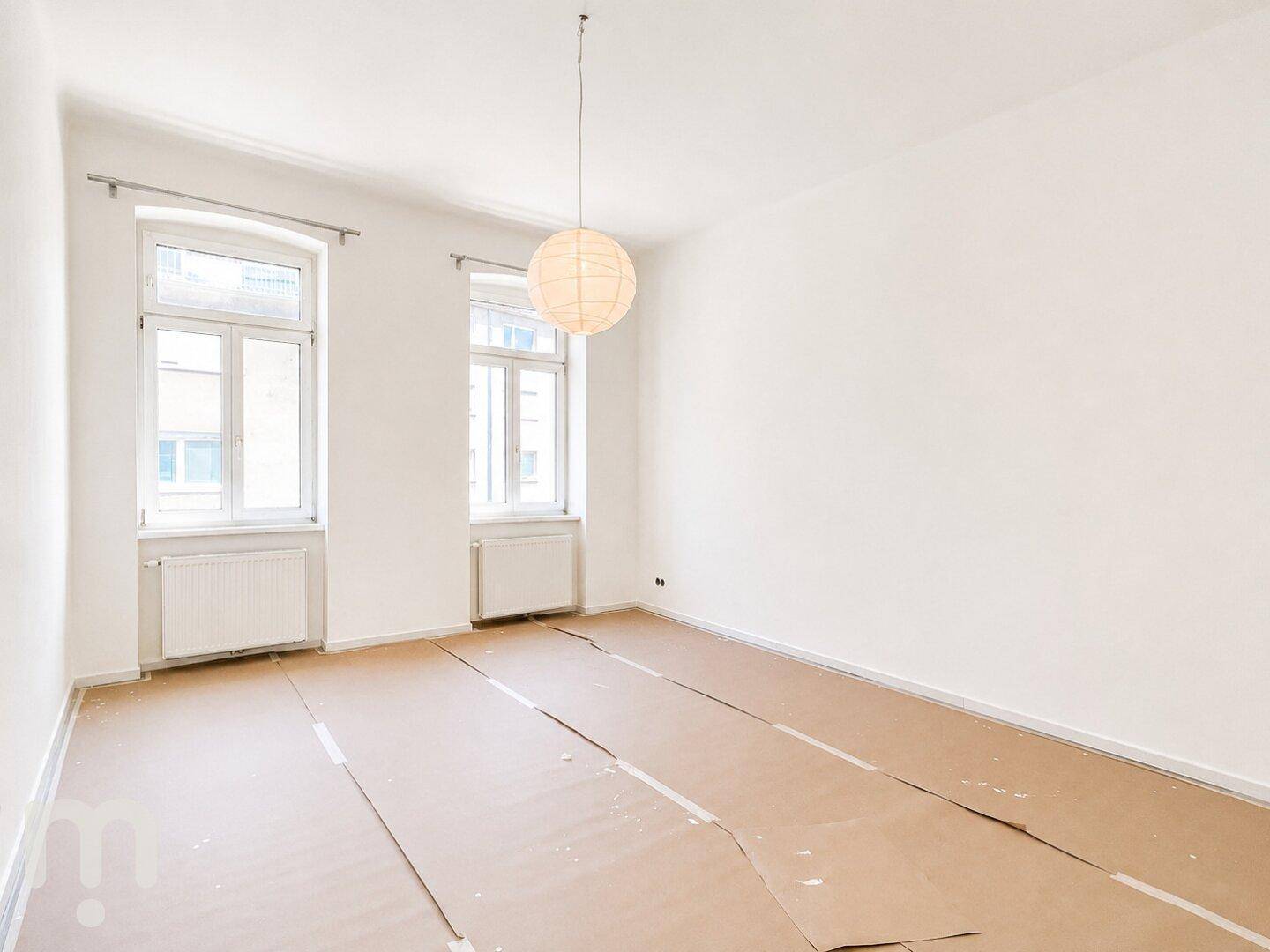 Geräumiges, helles Zimmer mit zwei Fenstern und vorbereitetem Boden für die Endverlegung.