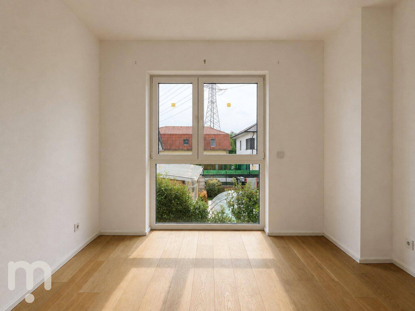 Geräumiges Zimmer mit Holzboden und großem Fenster, das eine weite Aussicht ermöglicht.