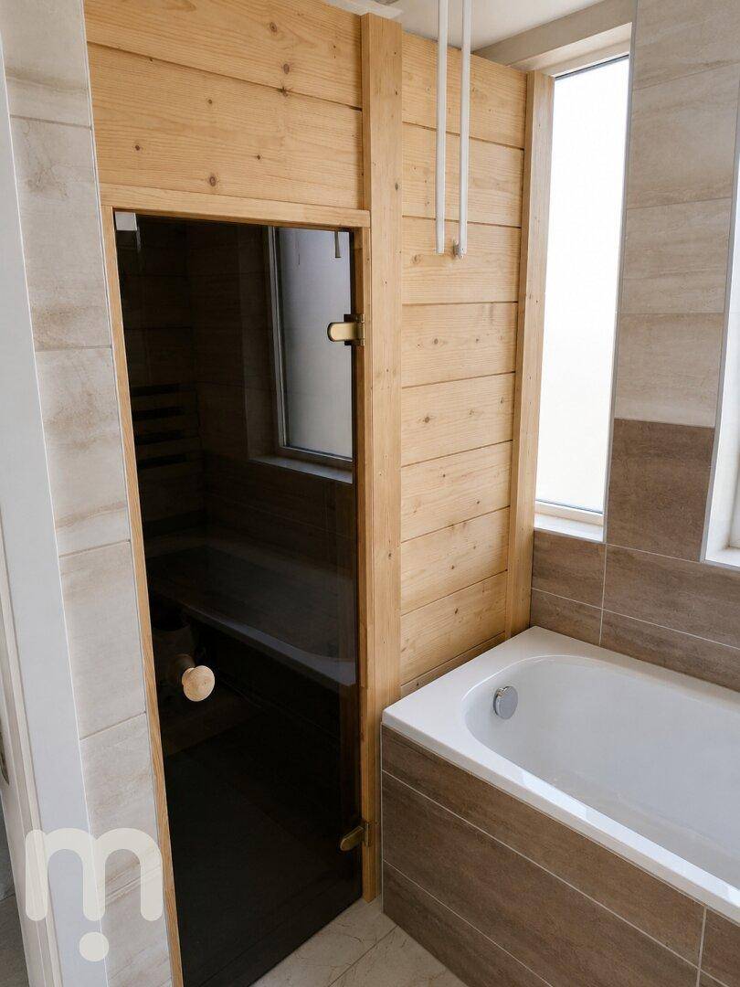 Badezimmer mit Badewanne und integrierter Sauna, die zum Entspannen einlädt.